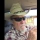 Fostoria News Man wearing cowboy hat and sunglasses inside vehicle.